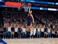 NBA赛场上球员高高跃起完成暴扣的瞬间观众席沸腾